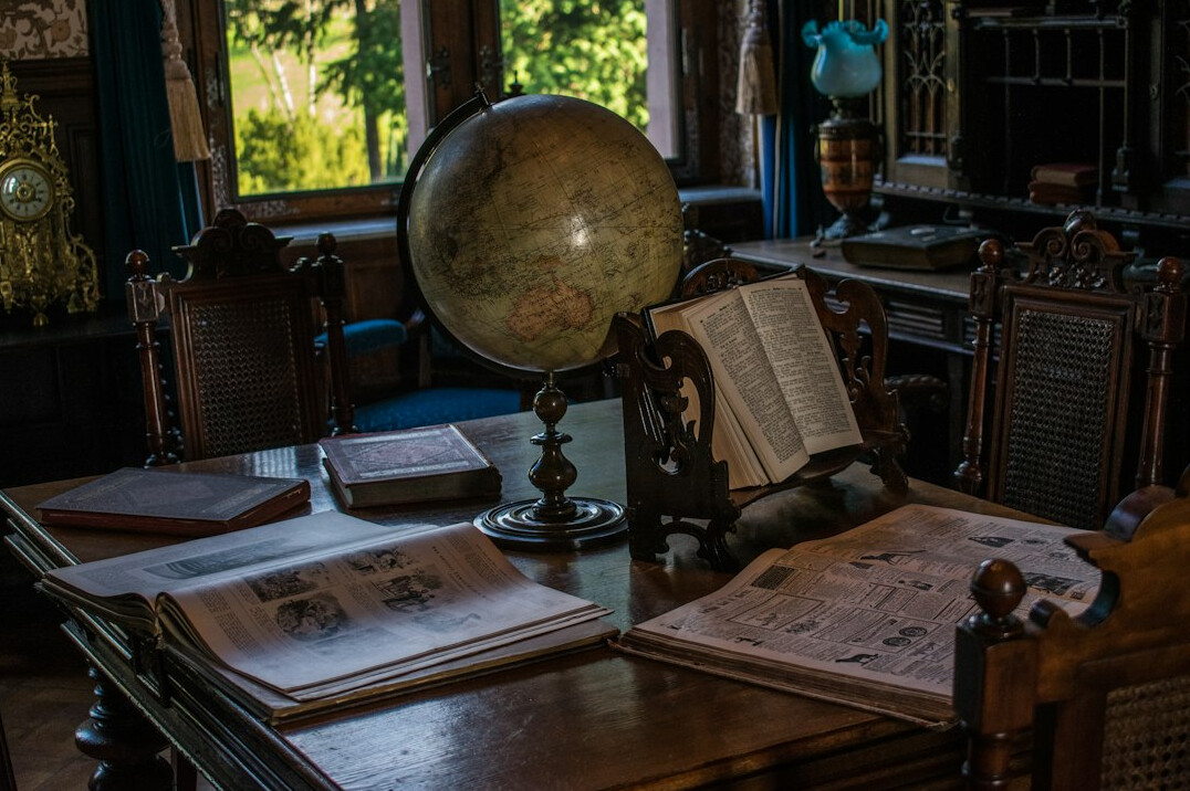 Antique desk with ink pen, books and an old map